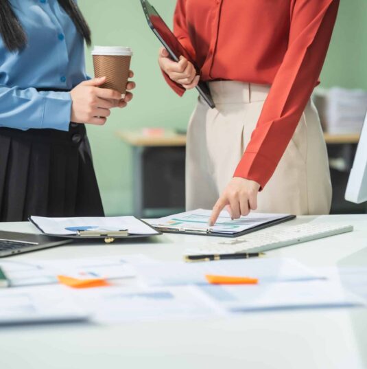 two-asian-business-woman-work-at-a-desk-discussin-2025-02-15-13-34-34-utc Two Asian Business Woman at a Desk